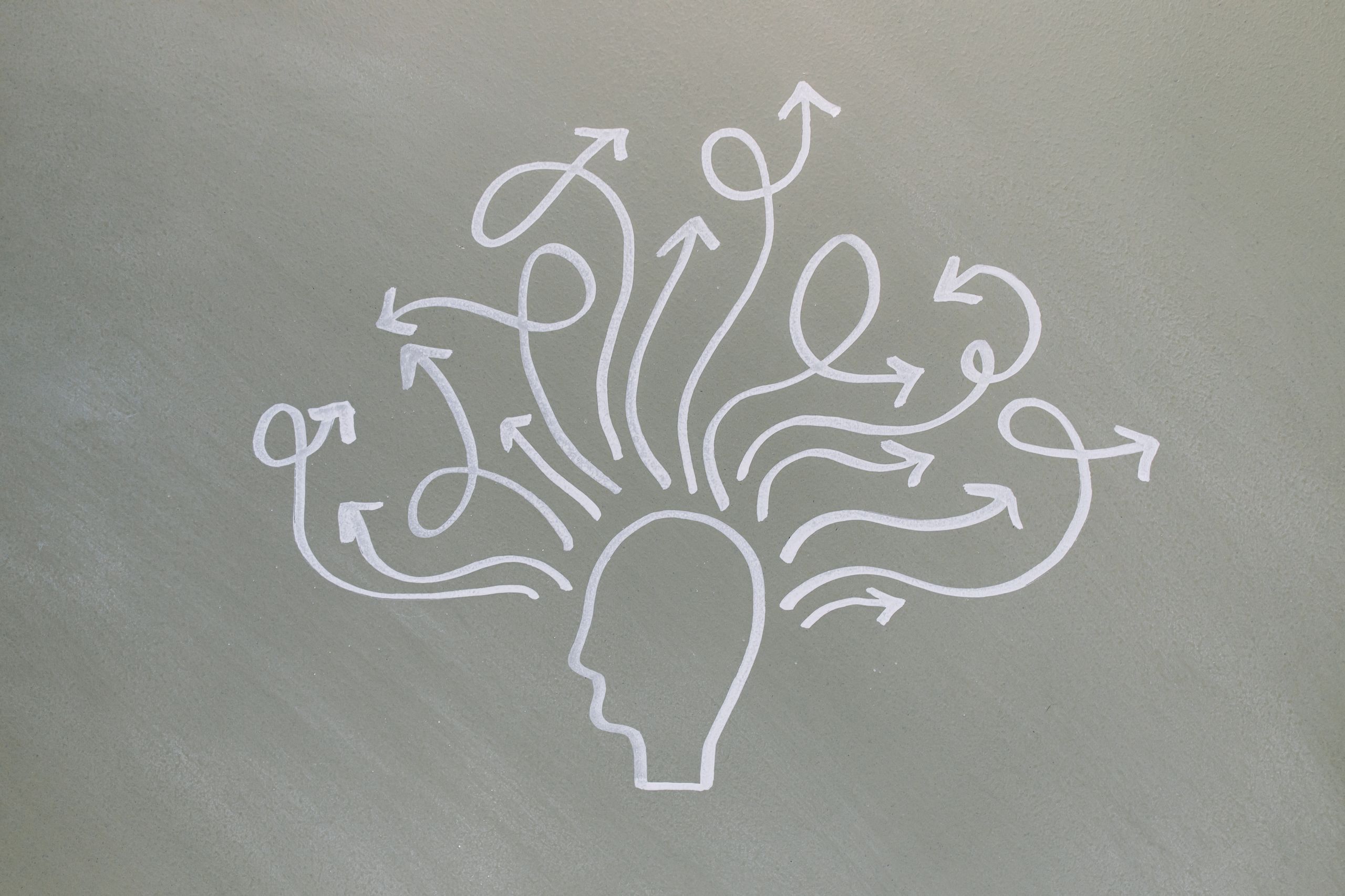 Conceptual chalk drawing illustrating mental health challenges with arrows representing thoughts.